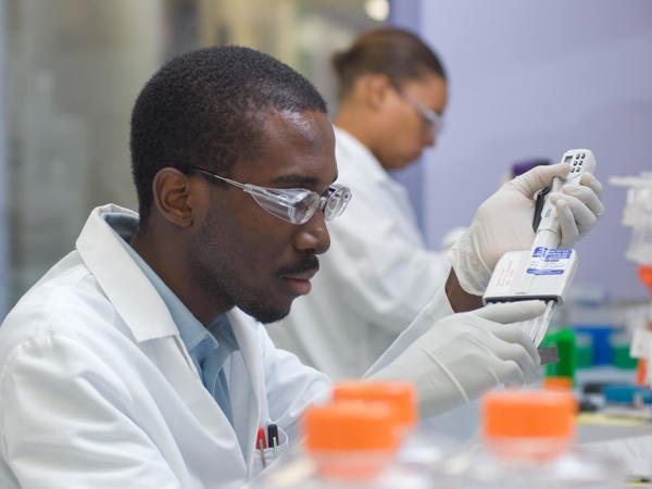 a man wearing white lab coat and goggles